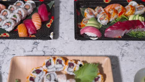 a drop-down shot of a table filled with a variety of assorted sushi rolls, showcasing different types of sushi. ideal for highlighting japanese cuisine, food displays, and sushi presentations.