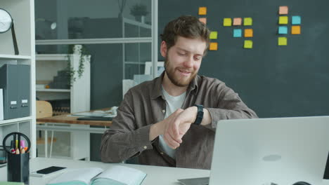 man checking smartwatch in office