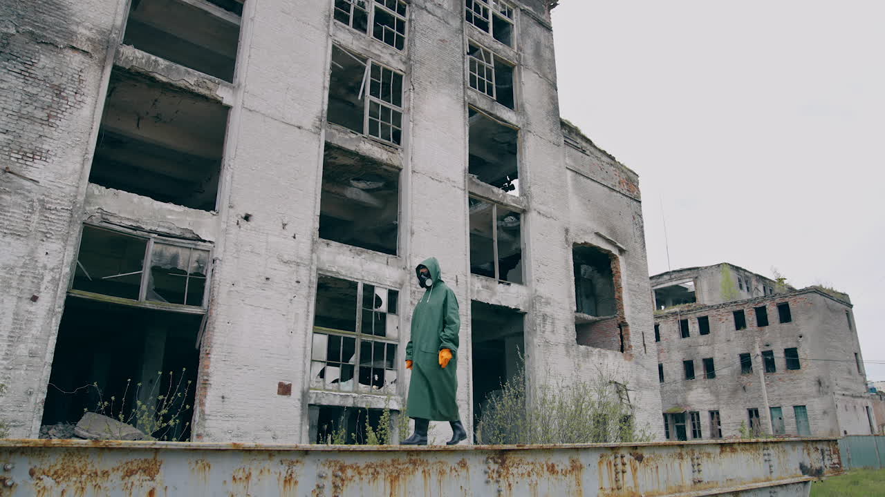 Person in radioactive zone. Human in chemical protective suit and mask walking on the background of destroyed buildings. Biological attack.