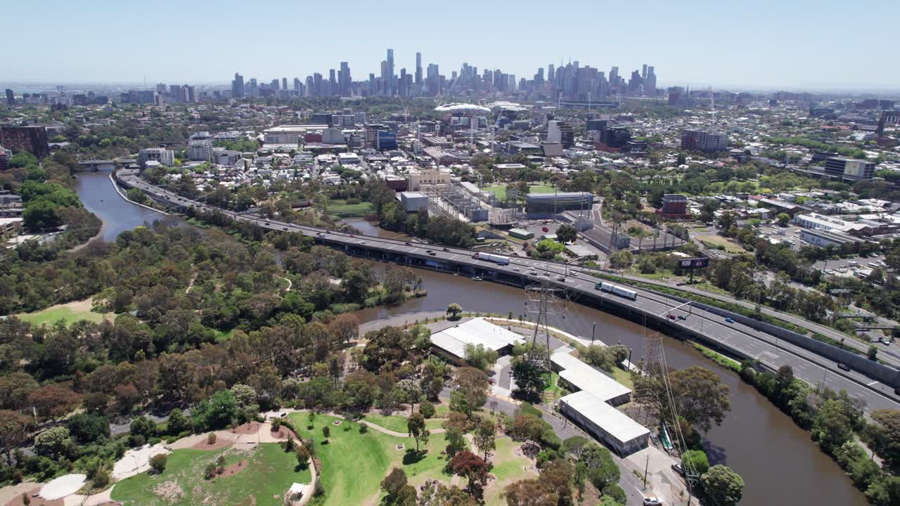 Pohled dronem za slunečného dne na východní předměstí Melbourne podél řeky Yarra a panorama města Melbourne v dálce, Victoria, Austrálie. Prosinec 2025
