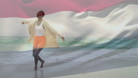 animación de la bandera de los países bajos ondeando sobre una feliz mujer afroamericana corriendo por el agua