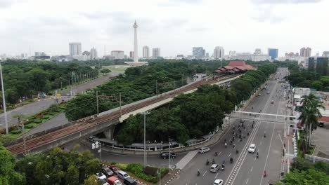 Aerial-view-of-the-National-Monument-with-crowded-vehicles-at-the-gambir-train-station-in-the-city-of-Jakarta,-Indonesia