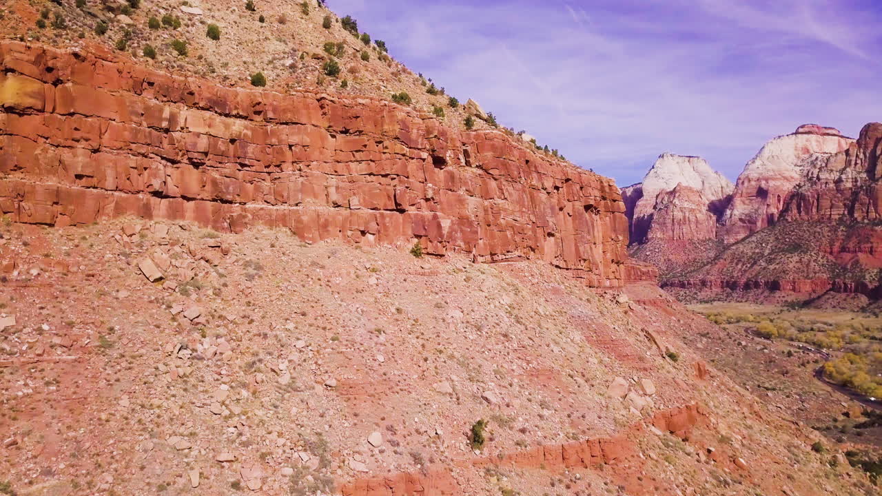 un dron vuela más allá de una pared de roca para revelar un valle glorioso y una cordillera más allá