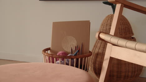 knitting equipment in a basket standing by a chair