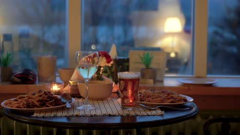 cozy dinner setting with spaghetti and drinks on a table, warm indoor lighting, evening vibe