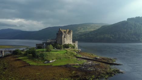 Castillo-De-Eilean-Donan-En-Las-Tierras-Altas-De-Escocia,-Reino-Unido-_-Drone-Disparó-La-Puesta-De-Sol-Con-Un-Hermoso-Lago,-Orbitando-Lentamente