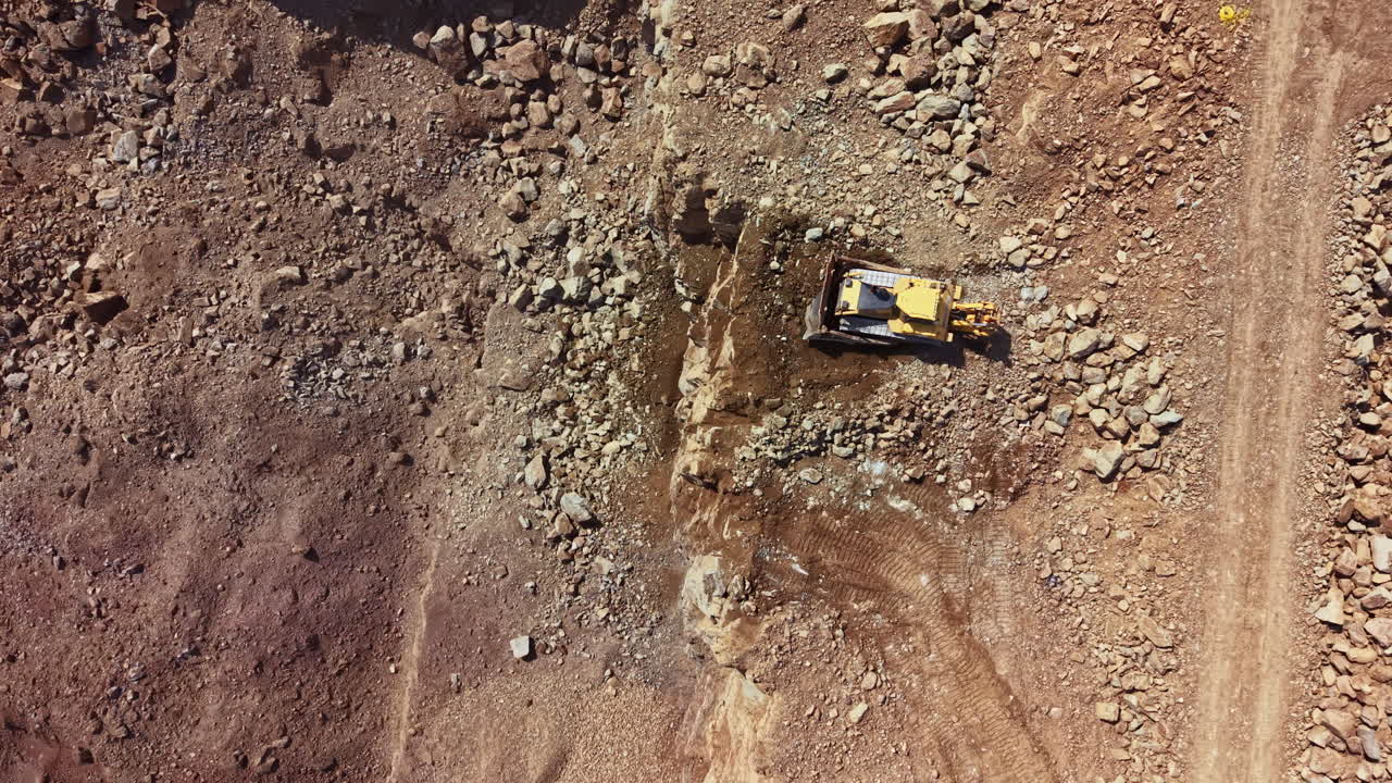Luftfoto af bulldozer, der arbejder i et stenbrud