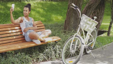 cheerful model taking selfie in park