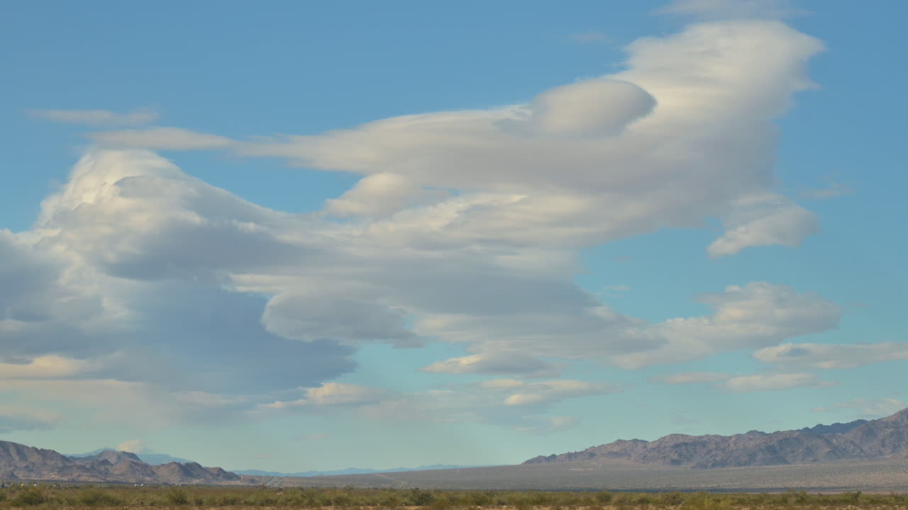 hermosas y únicas nubes blancas escénicas en el cielo azul sobre el paisaje desértico de california, acercar la toma