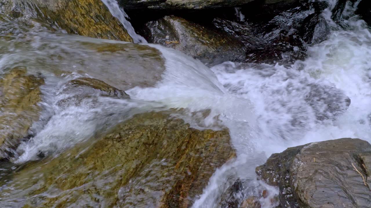 salpicaduras de agua sobre rocas lisas en cascadas de cristal cerca de mojones en queensland, australia