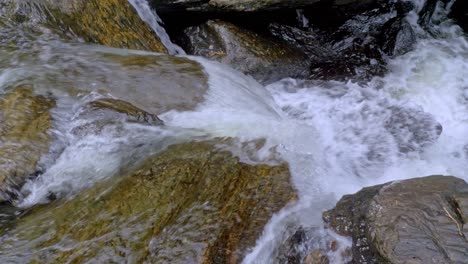 splashing water over smooth rocks at crystal cascades near cairns in queensland, australia