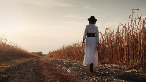 Farmer-in-a-dress-and-hat-walks-in-a-field-of-ripe-corn-2