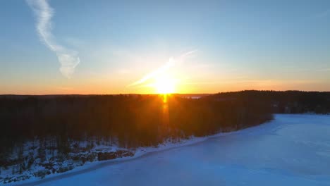 Flying-away-from-the-sunset-over-a-frozen-lake-in-the-winter