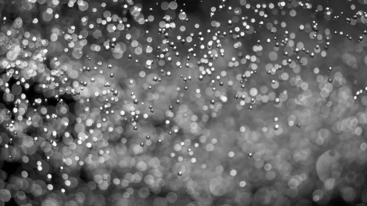 Floating abstract particle bokeh on dark background. Shot on super slow motion camera 1000 fps.