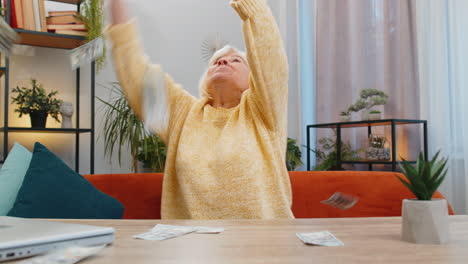 money cash dollar rain falling on senior woman celebrating success win pension lottery jackpot luck