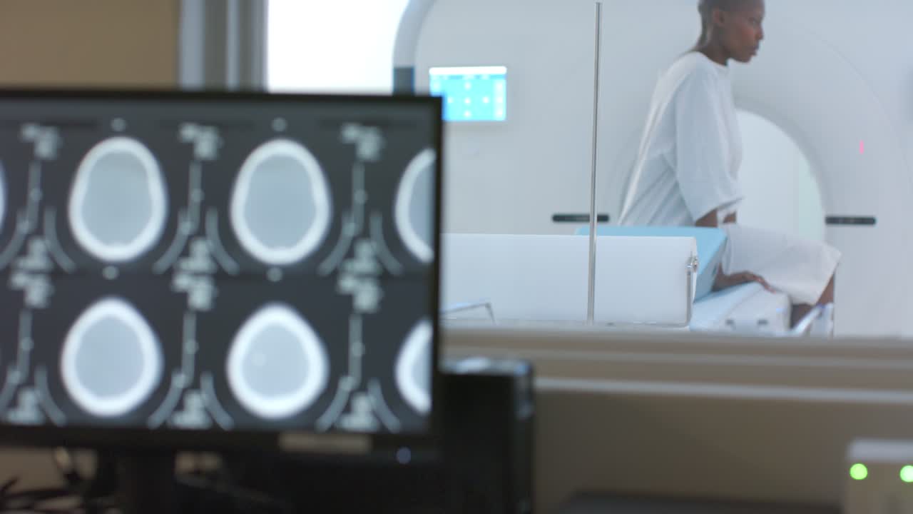 Quando lo scanner TAC completa, una donna in piedi in ospedale tiene in mano un oggetto e si prepara ad uscire.
