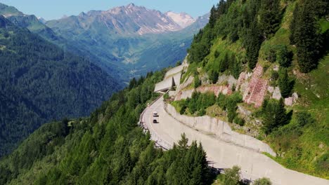 a winding mountain road cuts through the breathtaking swiss alps on a sunny day