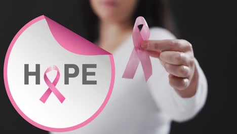 Animation-of-hope-text-over-caucasian-woman-with-pink-ribbon-on-black-background