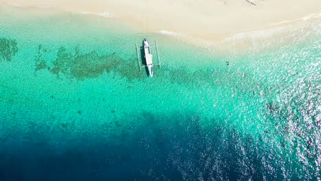 Verankertes-Boot,-Das-Auf-Dem-Klaren-Wasser-Der-Türkisfarbenen-Lagune-Schwimmt,-Das-Auf-Dem-Weißen-Sand-Eines-Exotischen-Strandes-Fließt,-Kopierraum-Mit-Farbenfroher-Meeresstruktur