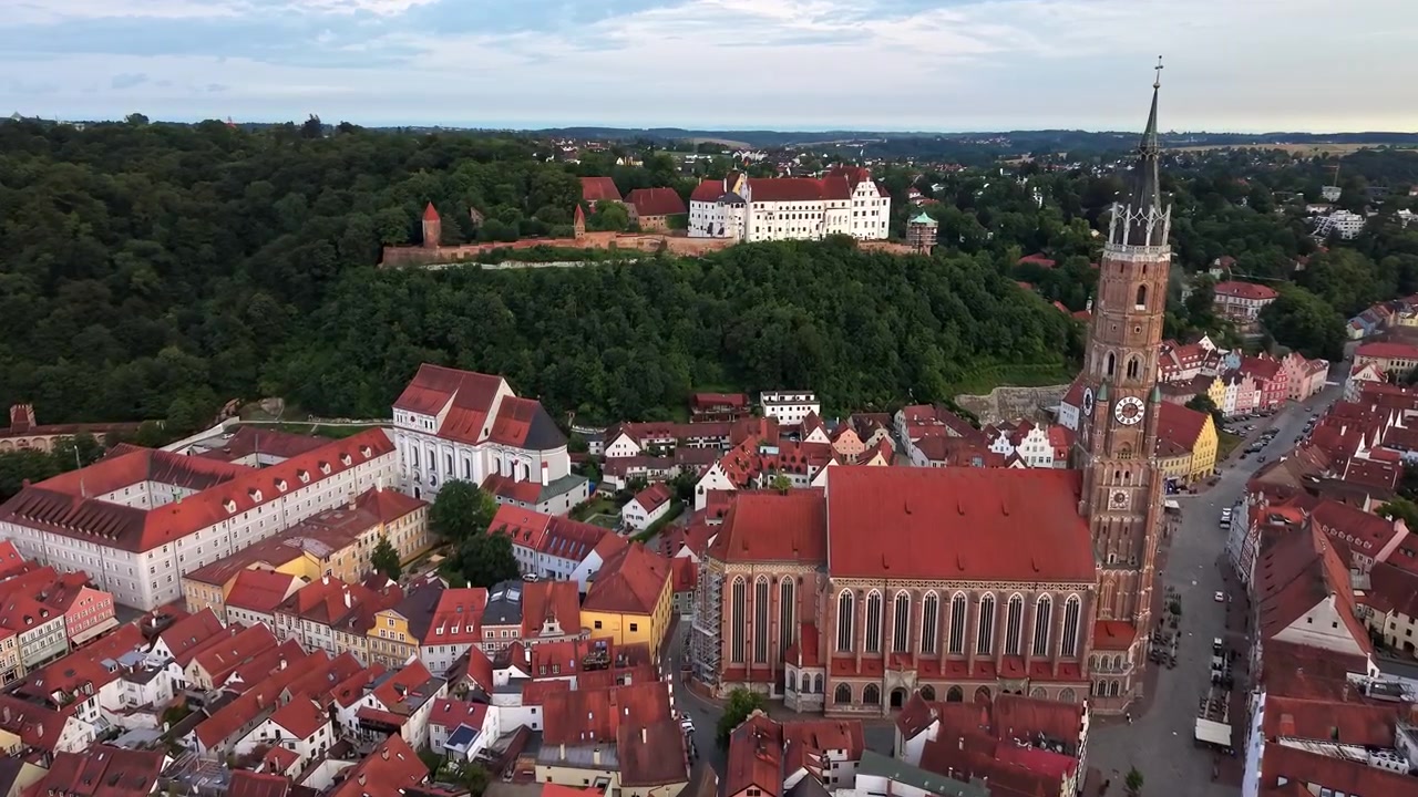 Veduta aerea con drone dei tetti del centro storico, della Chiesa di San Martino e del Castello di Trausnitz sulla collina boscosa sovrastante, Landshut, Germania