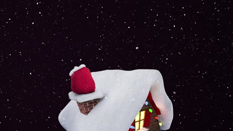 nieve cayendo sobre el icono de la casa cubierta de nieve contra un fondo negro