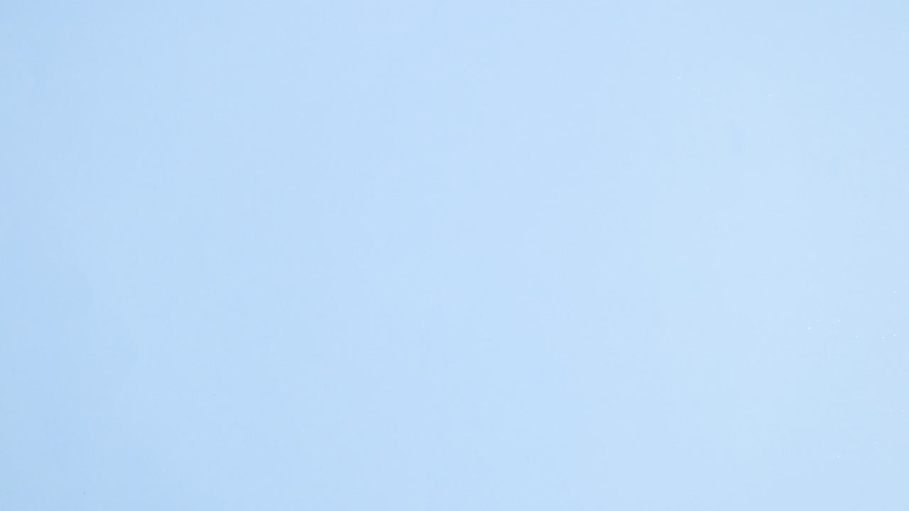 los huevos vibrantes de pascua aparecen en una tela esponjosa sobre un fondo azul pastel brillante.