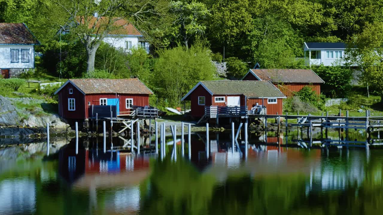 Picturesque red cottages along the Bohuslän archipelago with peaceful waters reflecting