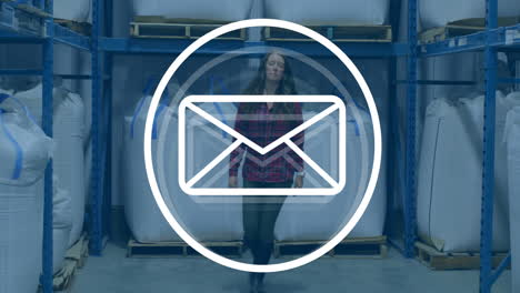 animation of envelope icon over caucasian female worker in warehouse