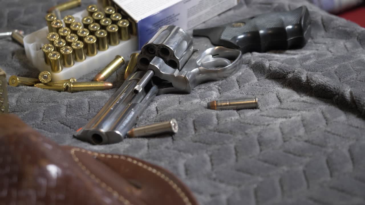 60p-slomotion: inclinación lenta hacia arriba con bastidor de enfoque de una funda de cuero a una pistola nueva y brillante