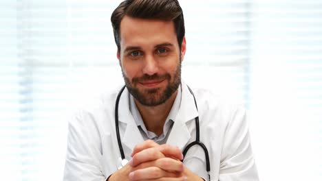 Portrait-of-male-doctor-sitting-at-desk