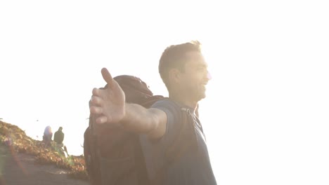 happy man with camping backpack standing with flying hands