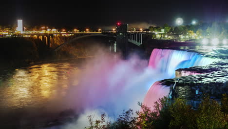 niagara falls at night with the glow of the city lights behind 2