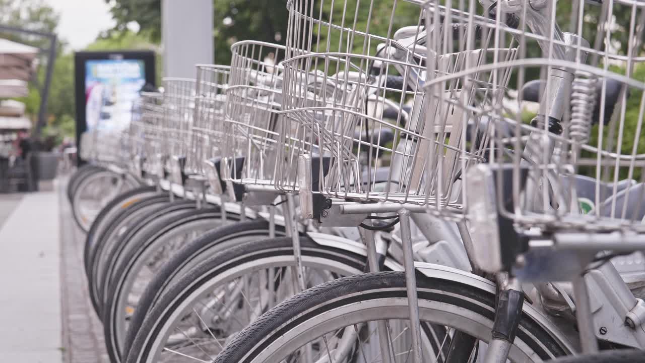 Row of city commuter electric rental bicycles at rental station stand