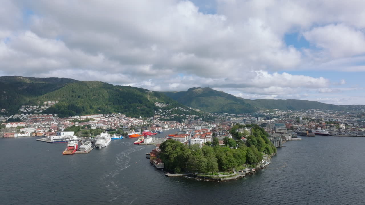 Drone som glir sideveis langs Bergens kystlinje, med fjorder og fjell i sikte