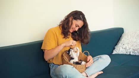 una mujer joven juega con sus dos gatitos lindos