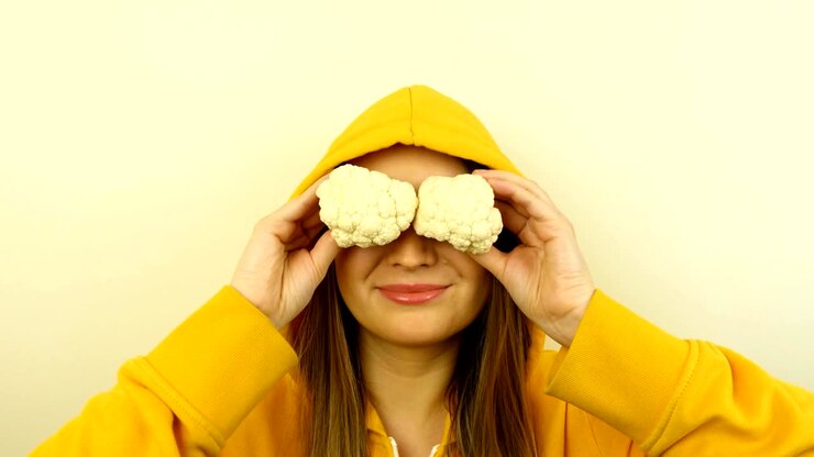 Fancy caucasian model with fresh vegetables on eyes. Stop motion looped.