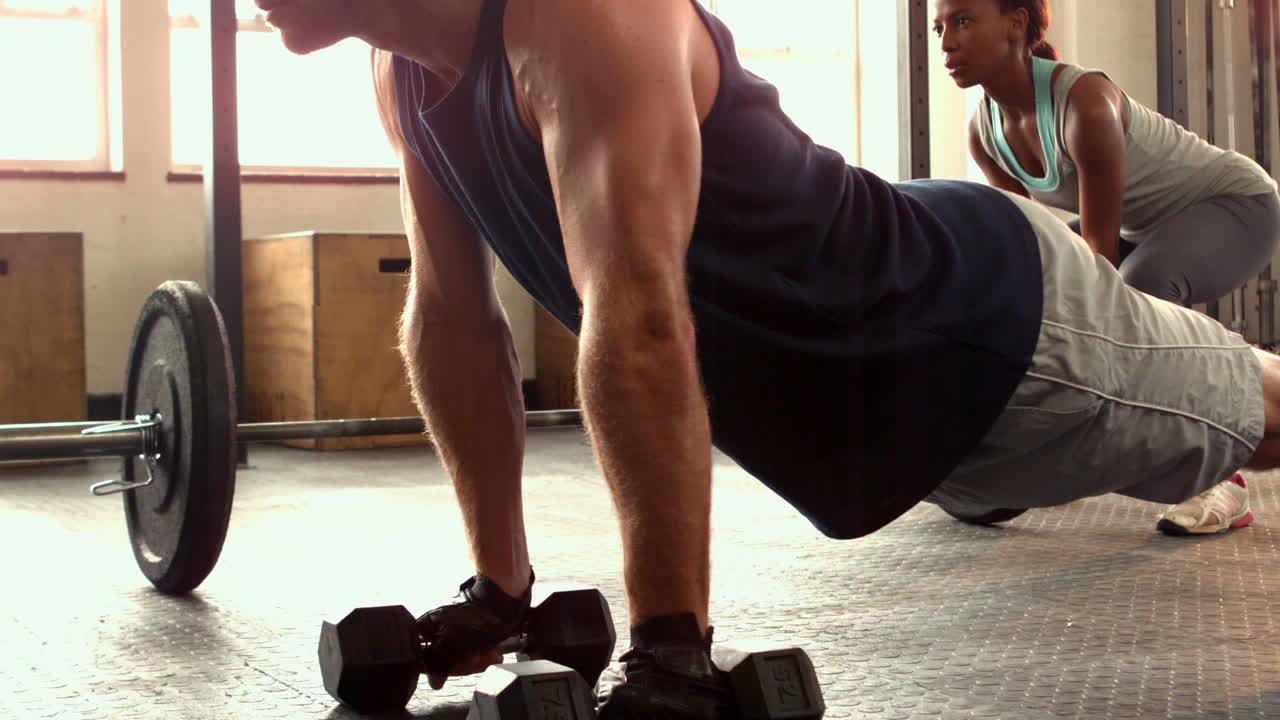hombre en forma haciendo flexiones en el estudio de crossfit