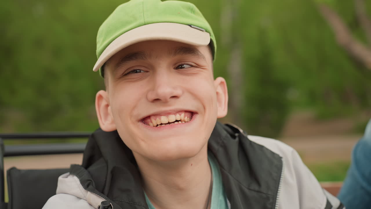 Joyous Friendship Outdoors, Man With Wheelchair Laughs Happily Outside, Cheerful Scene Of Companionship In Spring, Man In Wheelchair And Caregiver Share Joyful Springtime Moment Together