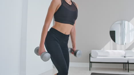 young fit and energetic woman doing sport workout and fitness lunge exercises with weights for healthy lifestyle in living room at home during sunny day