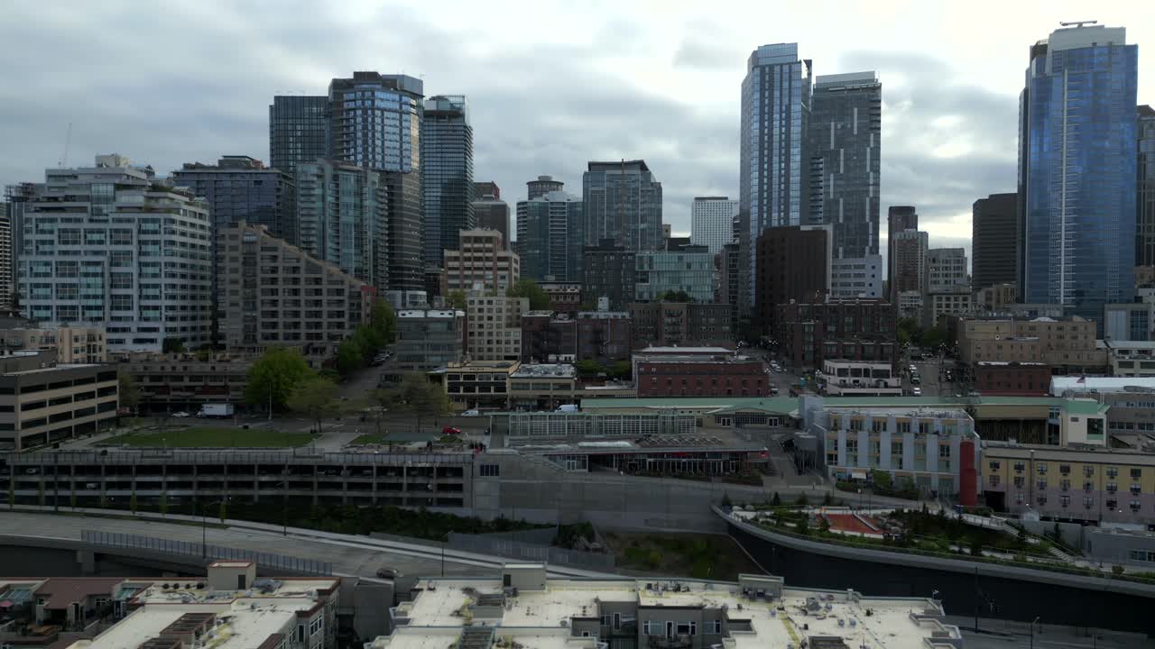 Panoramic view of bustling city backdrop at downtown Seattle Waterfront, Washington, USA during gloomy day - aerial drone shot