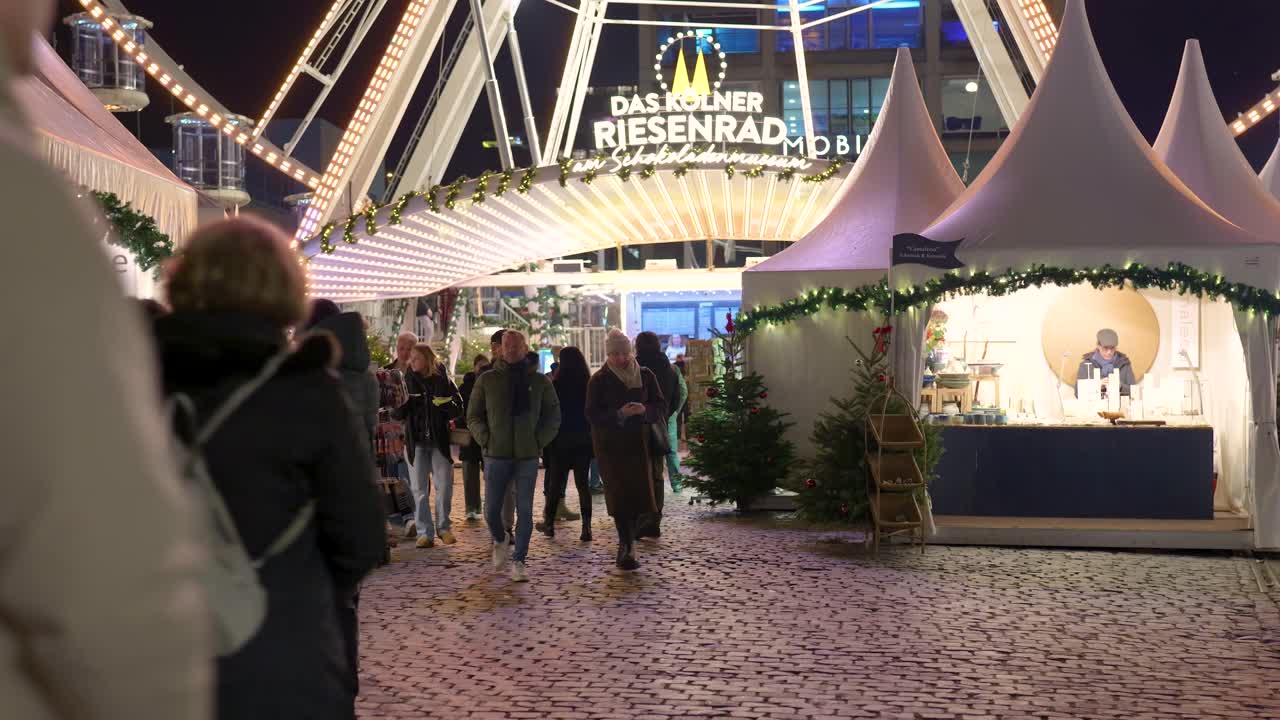 Mercatino di Natale di notte con ruota panoramica e folla di persone