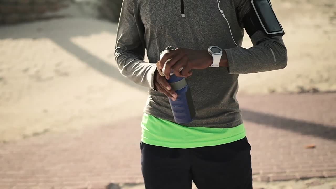 sección media de un hombre usando un reloj inteligente en la calle