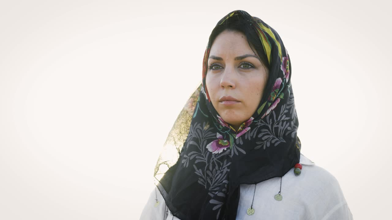 Portrait of a pensive middle eastern woman wearing a hijab outdoors