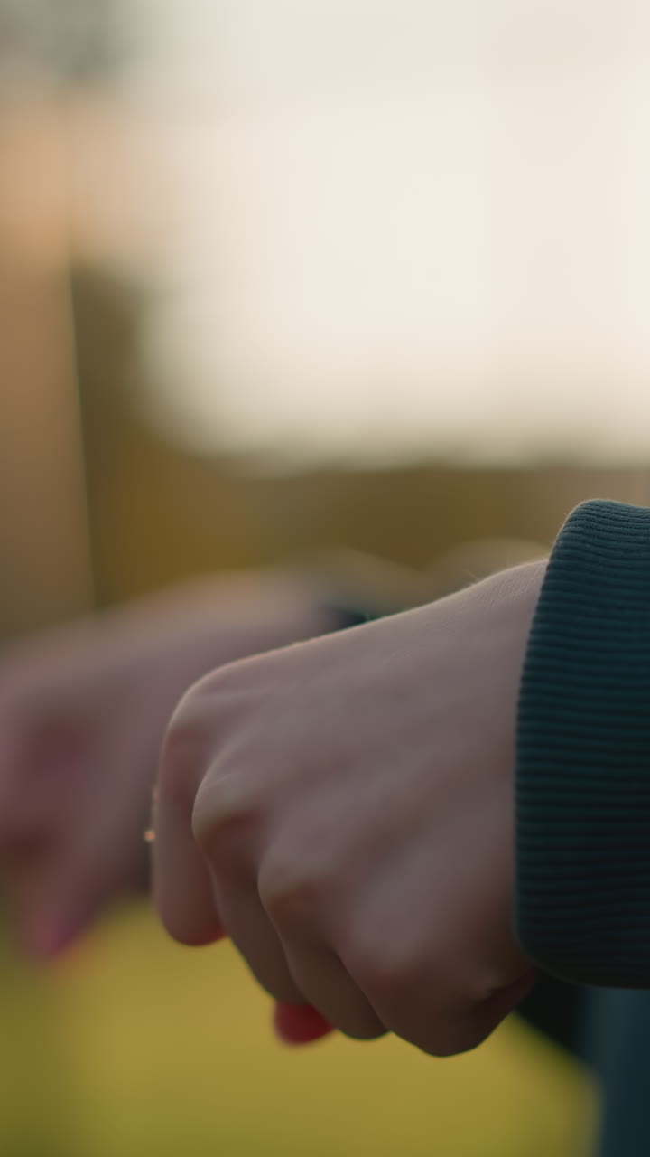 primer plano de un individuo que gira la muñeca con ropa verde con fondo borroso, creando una sensación de movimiento y centrándose en la acción de la muñaca, capturado en un entorno al aire libre