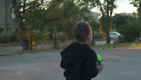 caucasian greek boy, playing with a ball outdoors