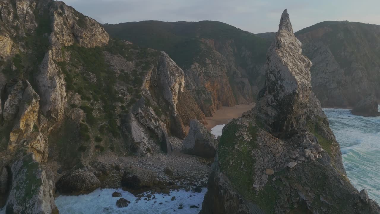 Ursa Beach with rocky cliffs during foggy day in Portugal