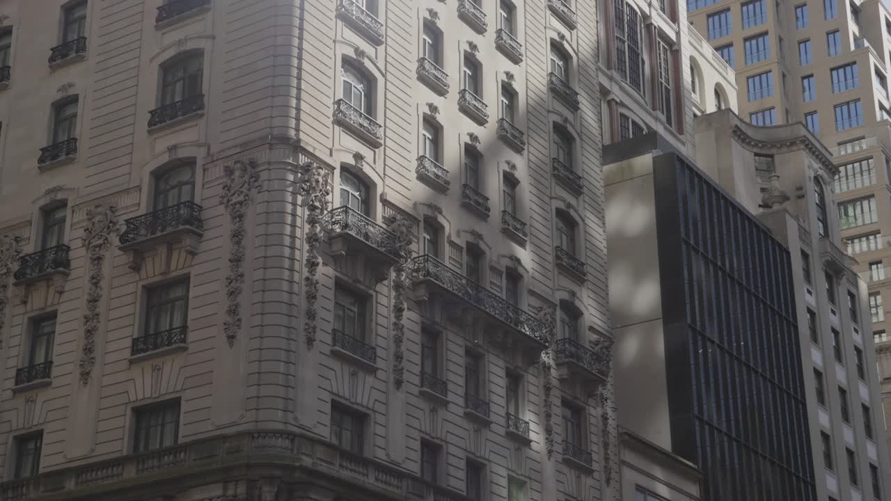 inclinarse desde una bandera estadounidense hasta un edificio de diseño arquitectónico clásico en la ciudad de nueva york