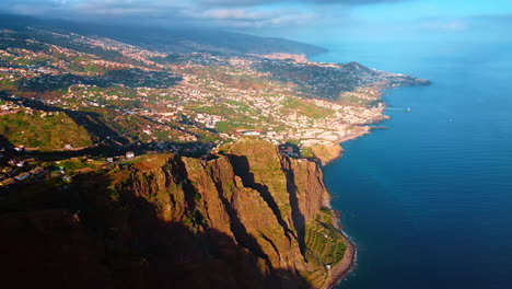 large city situated on the slope of the mountain descending to the north atlantic ocean. drone footage over the coast of madeira islands, portugal.