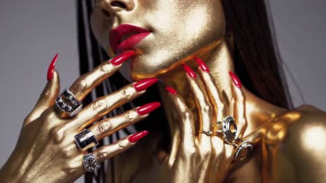 golden woman with red nails and rings