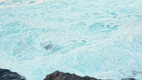 Rocky-coast-being-washed-with-waves,-slow-motion